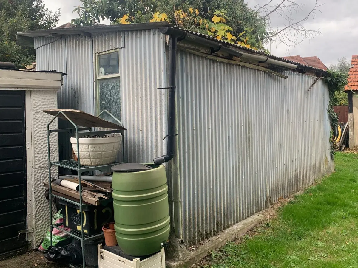 Garage with corrugated asbestos cement roof in London before removal